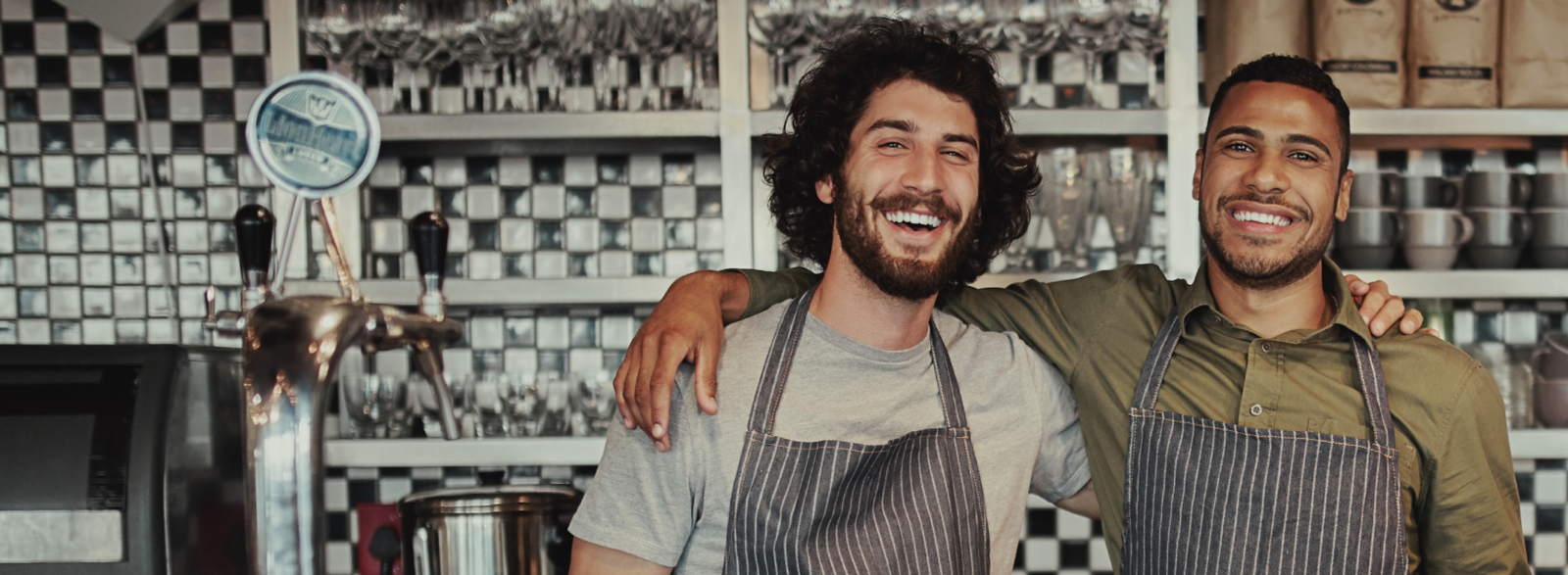 two men posing for a picture in a coffee shop